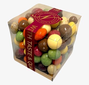 Foto av transparent chokladask med färgade kulor